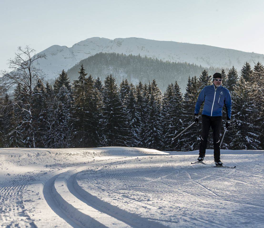 Herr skatet auf seinen Langlaufskiern in seinem Langlaufurlaub in Bayern