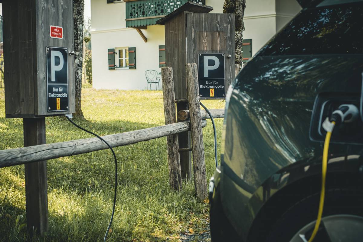 Eine E-Auto steht an der Ladestation vor dem Naturhotel in Bayern
