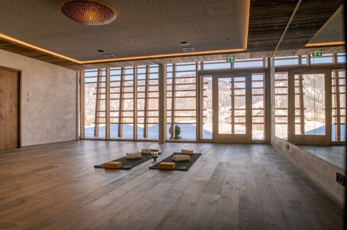 Large, bright room with a mirrored wall and two yoga mats for a yoga retreat near Lake Chiemsee