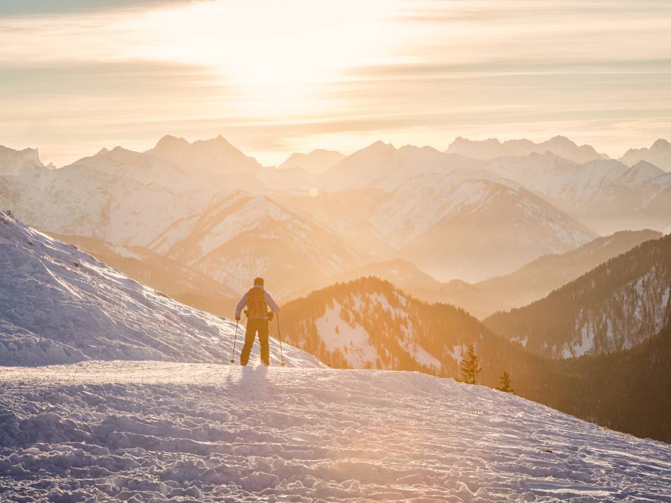 Skifahrer fährt eine Skipiste in gedämmtem Licht herunter