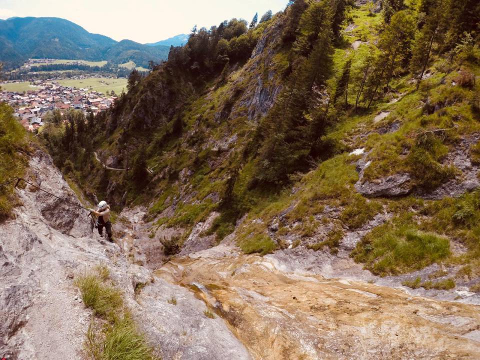 Ein Blick von oben auf eine Person beim Felsenklettern im Sommerurlaub in Bayern