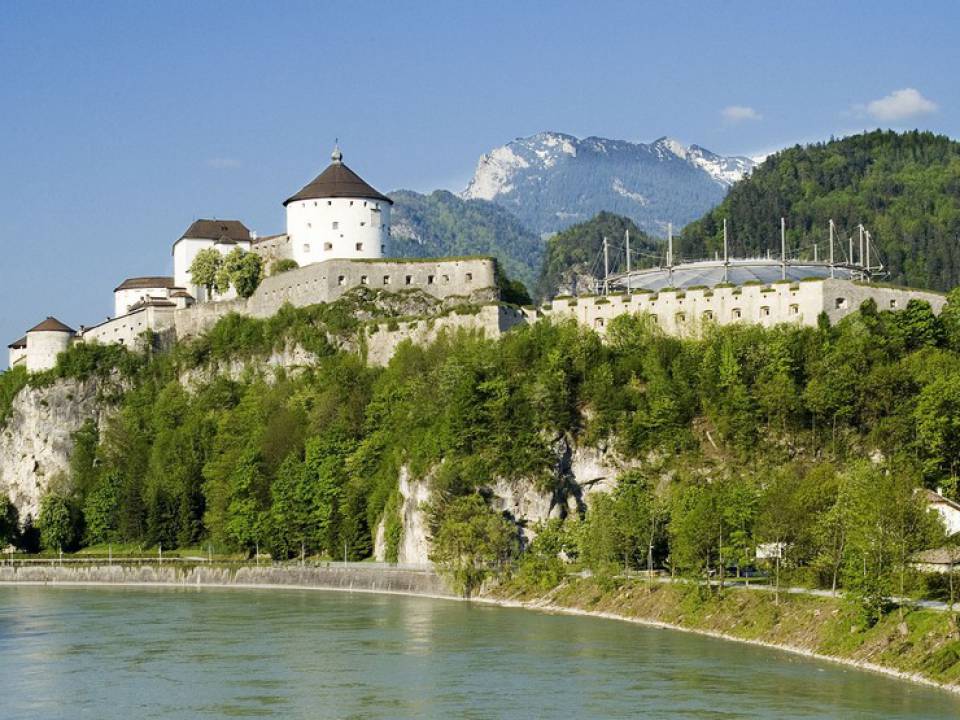 Fluss fließt an einer Burg vorbei, die sich auf einer Anhöhe befindet