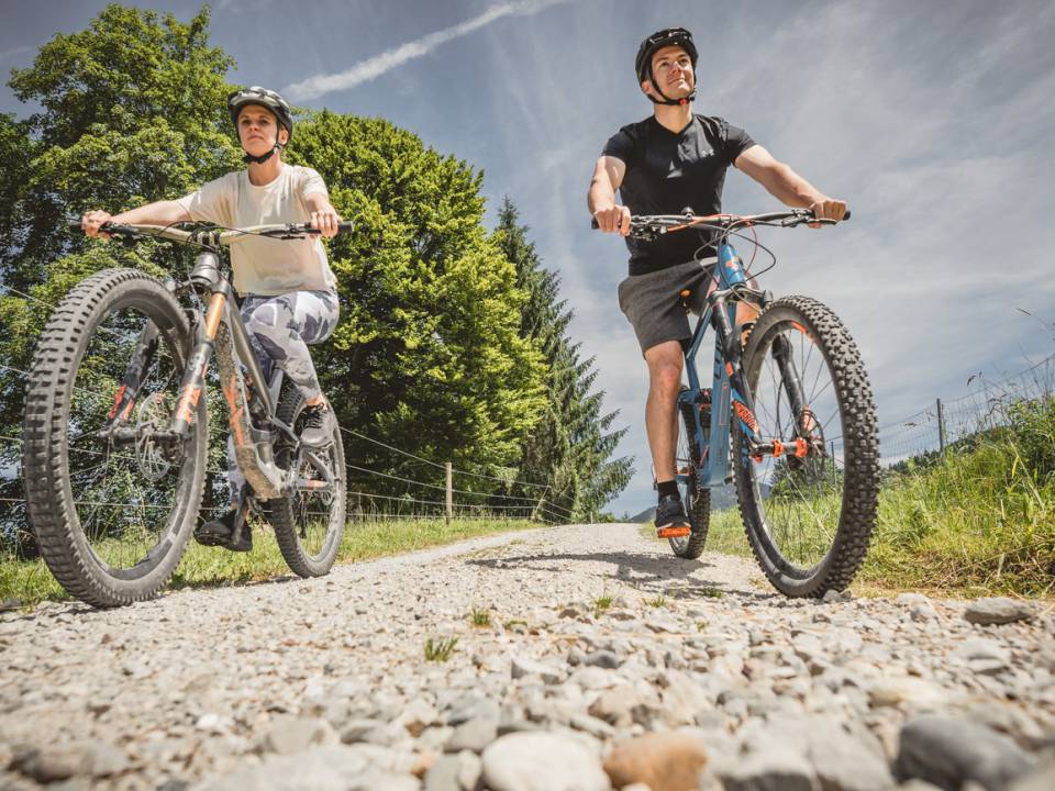 Zwei Fahrradfahren fahren mit ihren Mountainbikes auf einem Kiesweg