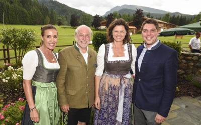 Zwei Herren und zwei Frauen im Dirndl stehen draußen in einer Reihe hintereinander